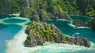 Turkuaz suyu olan ikiz göl. Gölcüklerin etrafında dolaşan tekneler. Coron, Palawan. Filipinler.