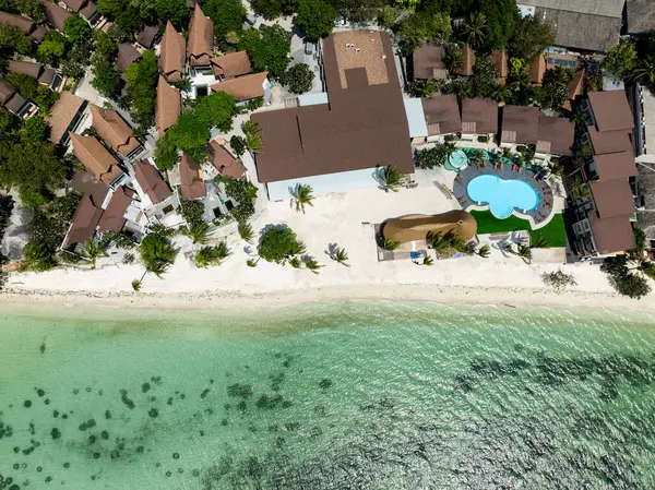 Palmiye ağaçları ve turkuaz sularla çevrili eşsiz şekilli bir havuzu olan sahil kenarı tatil köyü. Rin Nai Sahili. Ko Pha Ngan, Tayland.