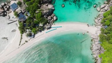 Turkuaz suların ve kayalık oluşumlarla çevrili beyaz kumların bulunduğu tropik ada plajı. Nangyuan Adası Sahili, Koh Tao, Tayland.