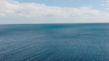 Mavi gökyüzü ve bulutların altında derin mavi deniz yüzeyi. Santa Fe, Tablas, Romblon. Filipinler.