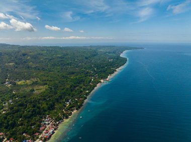 Yeşil ormanı ve mavi denizi olan tropik bir ada. Mavi gökyüzü ve bulutlar. Samal Adası. Davao, Filipinler.