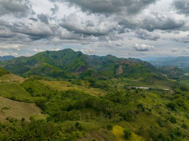 Dağlar yağmur ormanlarıyla, ağaçlar ve bulutlarla kaplı mavi gökyüzü. Mindanao, Filipinler