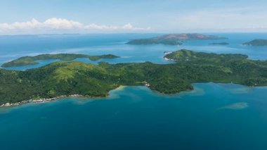 Yağmur ormanları olan tropikal adaların çarpıcı manzarası. Mavi deniz yüzeyi, mavi gökyüzü ve bulutlar. Deniz Burnu. Mindanao, Filipinler.