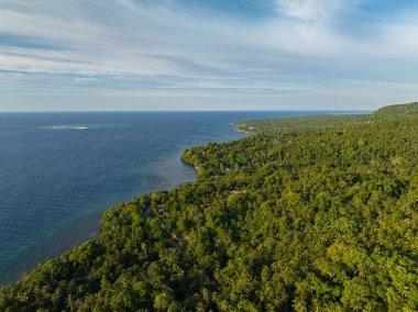 Kum tabakası ve derin mavi suyu olan Camiguin Adası. Mavi gökyüzü ve bulutlar. Filipinler.