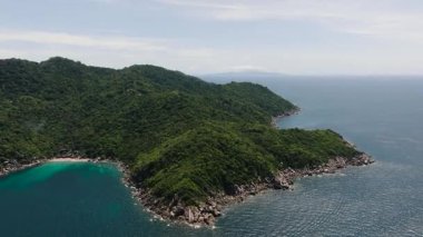 Berrak mavi okyanus ve parlak gökyüzü ile çevrili gür bitki örtüsü ile Rocky Adası. Koh Tao, Tayland.