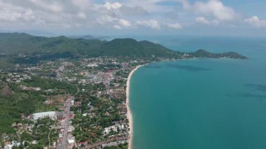 Bereketli yeşillik, turkuaz sular ve parlak bir gökyüzü altında manzaralı sakin kıyı şeridi. Ko Samui, Tayland.