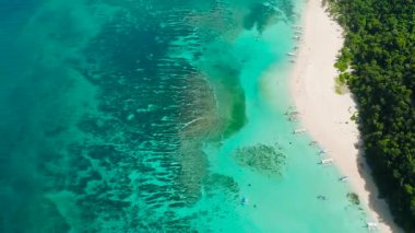 Güzel okyanus dalgaları ve hava manzaralı beyaz kum. Tekneler turkuaz suların üzerinde. Puka Deniz Kabuğu Sahili. Boracay, Filipinler.
