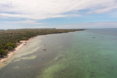 Plajlı bir ada, açık deniz suyunda balıkçı teknesi. Bantayan Adası, Cebu, Filipinler.
