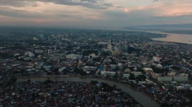 Davao City: Alacakaranlıkta bir sahil şehri. Bulutlu gün batımı ve gökyüzü. Mindanao, Filipinler.
