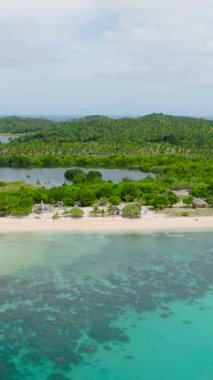 Turkuaz deniz suyu ve dalgalar kumlu sahile çarpıyor. Santa Fe, Tablas, Romblon. Filipinler. Dikey görünüm.