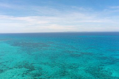 Mercan resifli mavi deniz, berrak sularda mercanlı deniz manzarası. Mavi gökyüzü ve bulutlar. Bantayan Adası. Cebu, Filipinler.