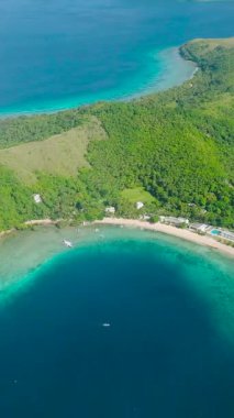 Mavi denizle çevrili Logbon Adası 'nın havadan görünüşü. Mavi gökyüzü ve bulutlar. Romblon, Romblon. Filipinler. Dikey görünüm.