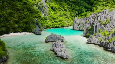 Beyaz plajlı Ubugon Koyu ve turkuaz deniz suyu ve mercanlı Cadlao Gölü. Cadlao Adası. El Nido. Palawan, Filipinler.
