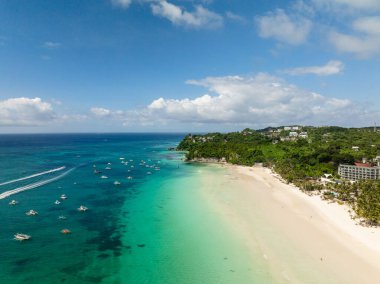 Beyaz kumsal manzarası ve berrak sularda yüzen turist tekneleri. Boracay Adası. Filipinler.