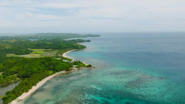 Canlı resiflerin ve yemyeşil çevrenin bulunduğu sakin tropikal kıyı şeridinin havadan görünüşü. Santa Fe, Tablo, Romblon, Filipinler.