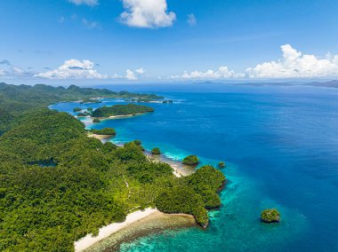 Beyaz kumlu sahil şeridi. Mavi gökyüzünün altında mavi deniz. Deniz Burnu. Bucas Grande Adası. Mindanao, Filipinler.