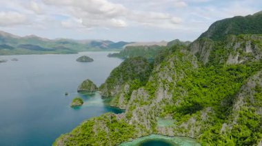 Kumsalı olan küçük İsletler ve mavi suyu olan lagünler. Coron, Palawan. Filipinler.