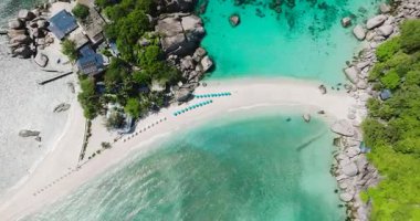 Turkuaz suların ve kayalık oluşumlarla çevrili beyaz kumların bulunduğu tropik ada plajı. Nangyuan Adası Sahili, Koh Tao, Tayland.