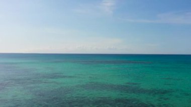 Mercan resifleriyle mavi deniz yüzeyinin drone görüntüsü. Mavi gökyüzü ve bulutlar. Bantayan Adası. Cebu, Filipinler.