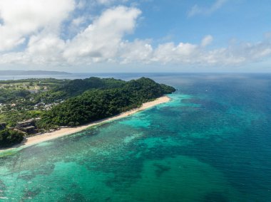 Beyaz kumlu, turkuaz deniz suyu ve dalgalı sahil şeridi. Puka Sahili. Boracay, Filipinler.