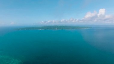 Açık okyanusun, berrak bir gökyüzünün altındaki sakin mavi suların havadan görünüşü. Carabao Adası. Romblon, Filipinler.
