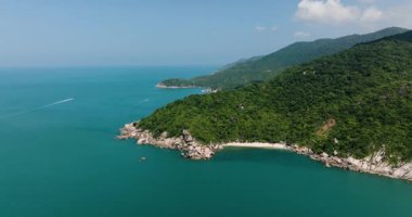 Güneşli bir günde açık turkuaz deniz ve kumlu plajlarla buluşan yeşil tepeler. Baş khontee. Ko Pha Ngan, Tayland.