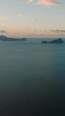 Alacakaranlıkta mavi denizle çevrili adalar, hava manzaralı. El Nido. Palawan, Filipinler. Dikey görünüm.