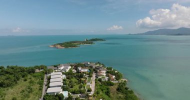 Çevresindeki modern villalar ve yemyeşil manzaralı turkuaz sularda küçük bir ada. Bo Put. Ko Samui, Tayland.