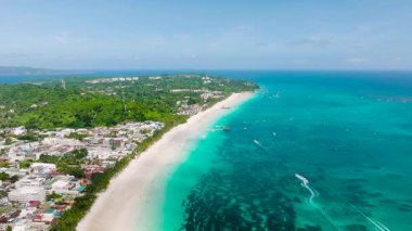 Kıyı manzarası turkuaz suları ve canlı yeşilliklerle kaplı beyaz kumsalları gösteriyor. Boracay Adası, Filipinler.