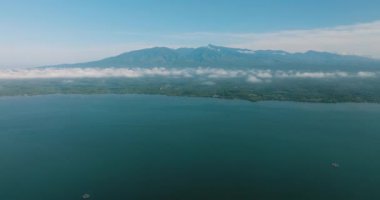 Mavi denizi ve dağların üzerindeki bulutlu tropikal ada. Lanao del Norte. Mindanao, Filipinler.