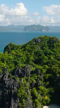 Miniloc Adası 'ndaki küçük adalar ve plajlar. Okyanus dalgaları kayalık kıyılara çarpıyor. El Nido, Filipinler. Palawan 'da. Dikey görünüm.