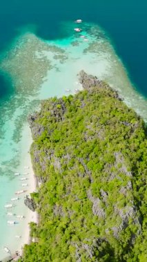 Palawan, Coron 'daki Banul Plajı' ndaki turist teknelerinin insansız hava aracı görüntüsü. Filipinler. Dikey görünüm.