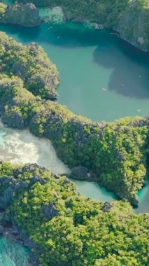 Miniloc Adası 'ndaki göl manzarası. Kano ve tekneler turkuaz suyun üzerinde. El Nido, Filipinler. Palawan 'da. Dikey görünüm.