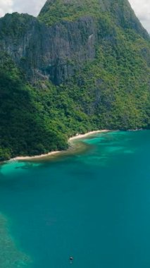 Cadlao Adası 'nda kıyı şeridinde turkuaz su ve mercanlar var. El Nido. Palawan, Filipinler. Dikey görünüm.