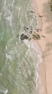 Deniz dalgaları ve güneş yansımalı kumlu sahil manzarası. Santa Fe, Tablas, Romblon. Filipinler. Dikey görünüm.