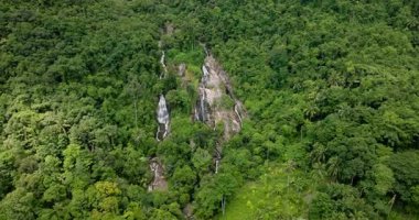 Yoğun tropikal ormanlarda şelale çağlıyor canlı yeşillik ve kayalarla. Na Mueang Şelalesi. Ko Samui, Tayland.