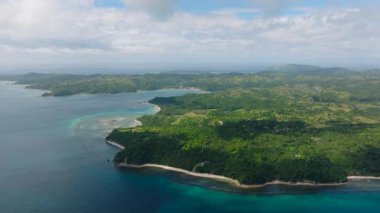 Canlı tropikal yeşillikler, kumlu kıyılar ve berrak mavi okyanus sularıyla geniş bir sahil şeridi. Santa Fe, Tablo, Romblon, Filipinler.