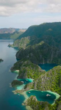 Kireçtaşı taşlı Barakuda Gölü. Mavi deniz, mavi gökyüzü ve Coron, Palawan 'da bulutlar. Filipinler. Dikey görünüm.
