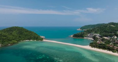 Turkuaz deniz, açık mavi gökyüzünün altındaki iki yeşil tepenin arasında kumlu bir şerit. Ko Ma Sahili. Ko Pha Ngan, Tayland.