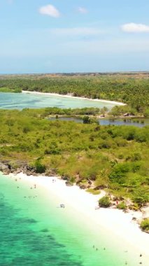 Beyaz kumlu ve kayalık sahilli tropikal plajların insansız hava aracı görüntüsü. Sandira Sahili. Bantayan Adası. Cebu, Filipinler. Dikey görünüm.