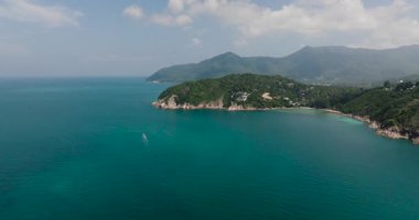 Geniş okyanus manzarası, yemyeşil tepeler ve ufuk çizgisiyle buluşan sakin turkuaz su. Ko Pha Ngan, Tayland.