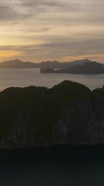 El Nido 'daki Tropik Günbatımı manzarası. Güzel kireçtaşı kayaları olan adalar. Palawan, Filipinler. Dikey görünüm.