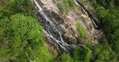 Canlı yeşil orman ve tropikal bitki örtüsüyle çevrili Rocky şelalesi. Na Mueang Şelalesi. Ko Samui, Tayland.