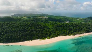 Turkuaz suları ve kıyı şeridinde canlı yeşillikleri olan beyaz kumlu bir sahil. Puka Kabuğu, Boracay Adası, Filipinler.