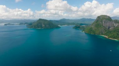 Arka planda mavi deniz, gökyüzü ve bulutlarla çevrili tropikal adaların havadan görünüşü. Palawan, Filipinler.