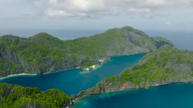 Açık mavi gökyüzü ve bulutların altında güzel doğal bir doğa. Tapiutan Adası ve Matinloc Adası 'nın havadan görünüşü. El Nido, Palawan. Filipinler.
