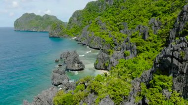 Okyanus dalgalarının Matinloc Adası 'ndaki kumsallara ve kayalara çarptığı hava manzarası. El Nido, Palawan. Filipinler.