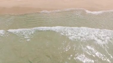 Güneş ışığı, kumlara çarpan berrak okyanus dalgaları üzerinde parlak dalgalar yaratır. Nacpan Sahili. El Nido, Palawan. Filipinler.