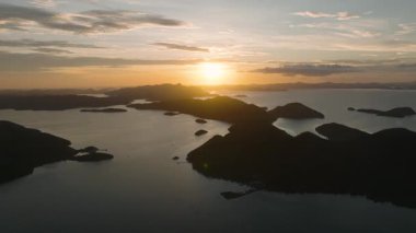 Güneş okyanusa altın yansımalar yapıyor. Günbatımı geçmişli tropik adalar. Coron, Palawan, Filipinler.