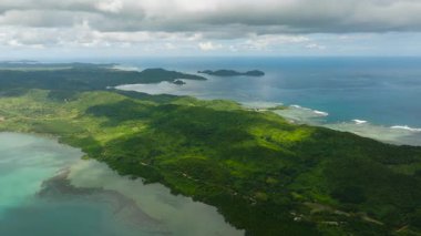 Okyanus dalgaları ve mercanlarla çevrili el değmemiş bir ada. Busuanga, Palawan, Filipinler.